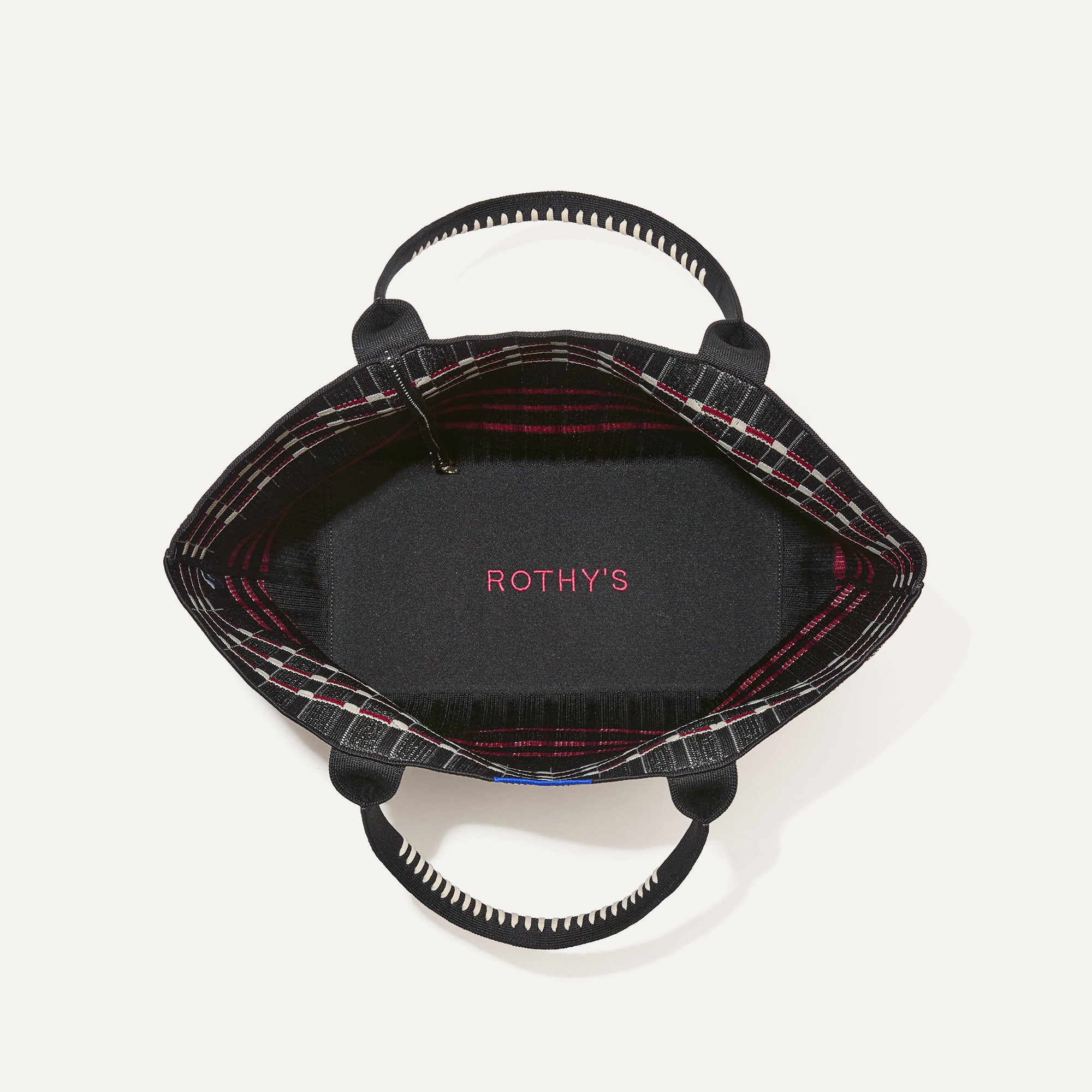 The Lightweight Tote in Newspaper shown open from the top, with base insert visible. 