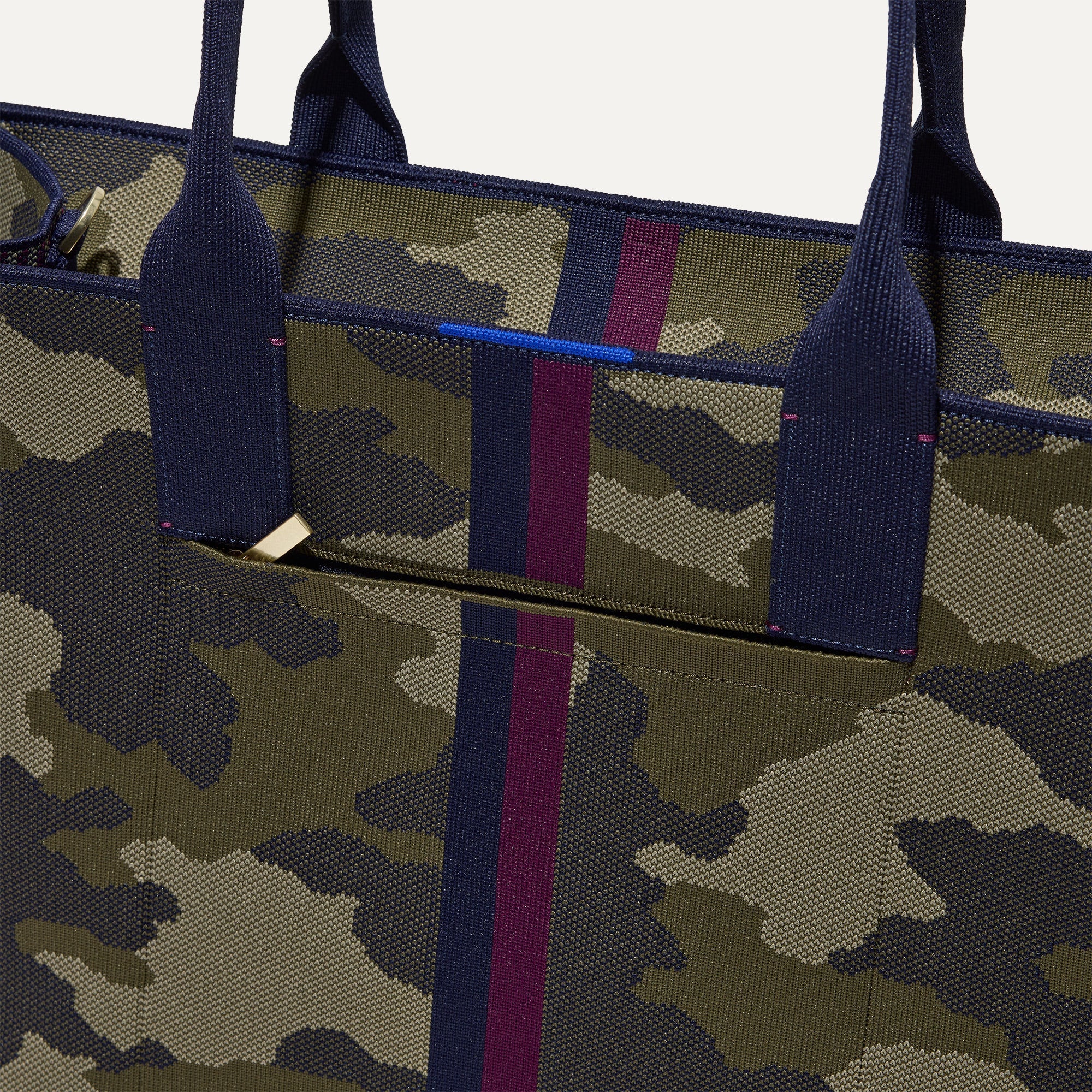 A closeup of The Classic Tote in Spruce Camo, focusing on the exterior zip pocket. 