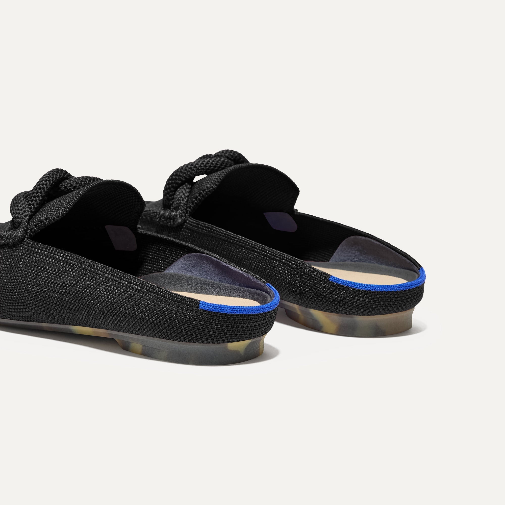 Close up of the heel of The Loafer Mule in Black, with Rothy's signature blue halo.