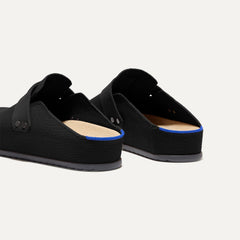 Close up of the heel of The Men's Clog in Soft Black, with Rothy's signature blue halo. 