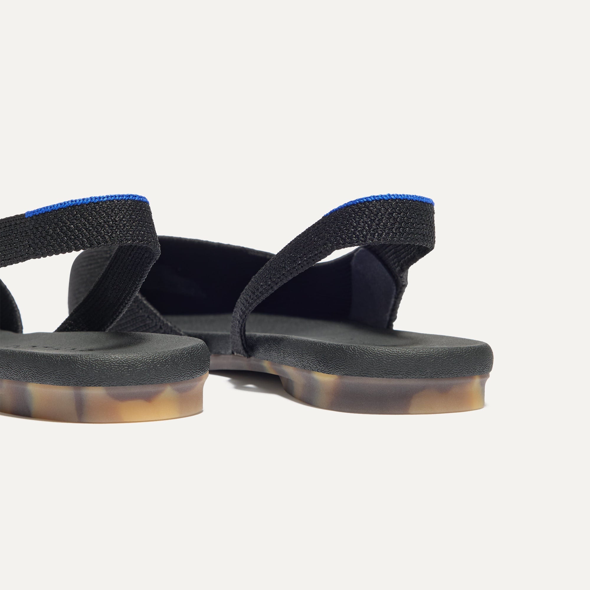 Close up of the heel The Almond Slingback in Black, with Rothy's signature blue halo.