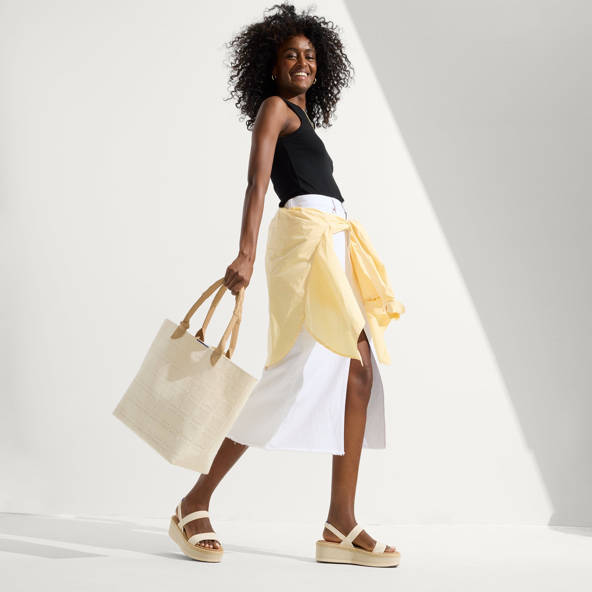 Alternative view of a model wearing The Lightweight Wedge Sandal in Salt.