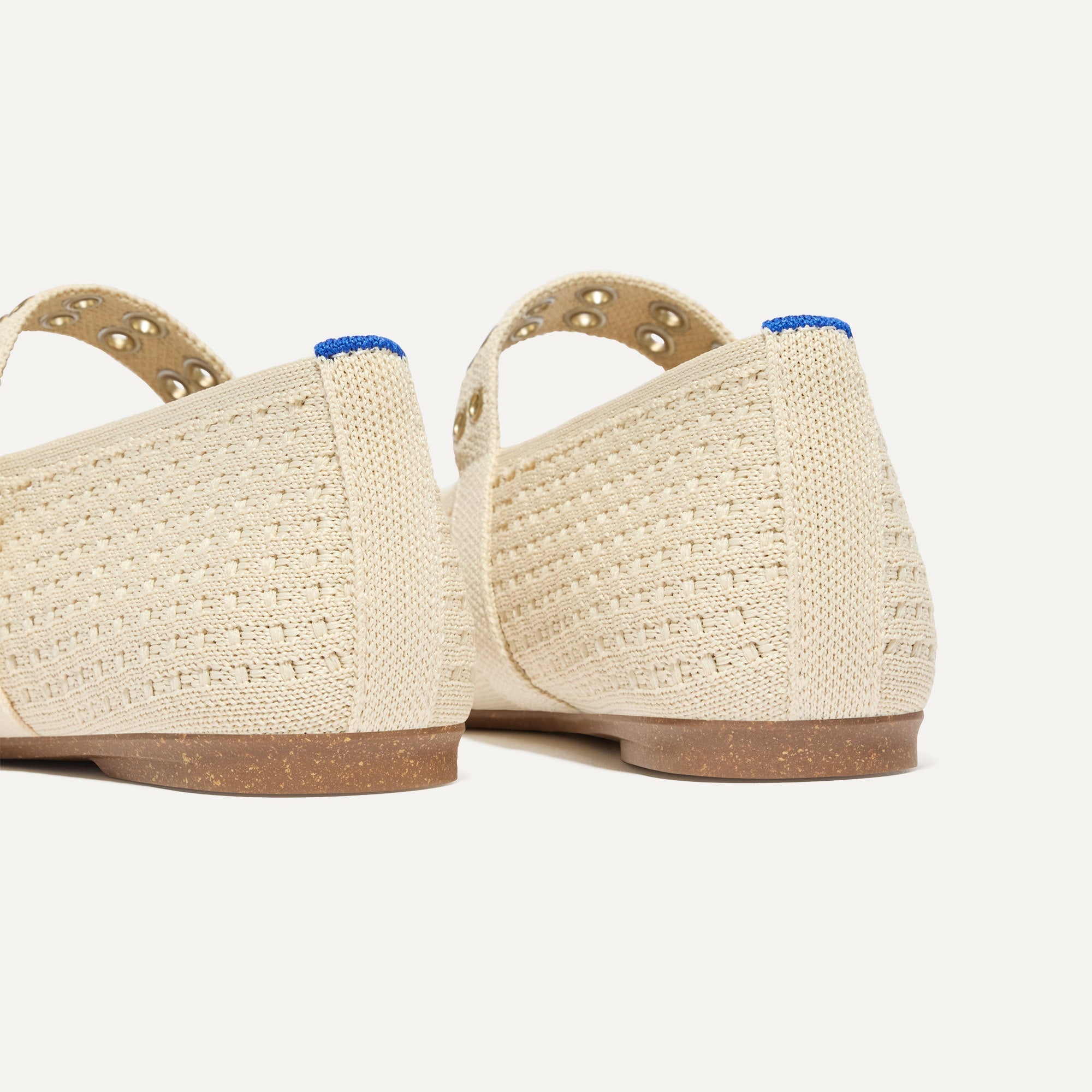 Close up of the heel of The Max Buckle Mary Jane in Off White Mesh, with Rothy's signature blue halo.